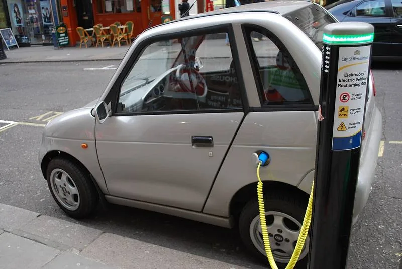 A small electric car charging at a street charge point in Westminster